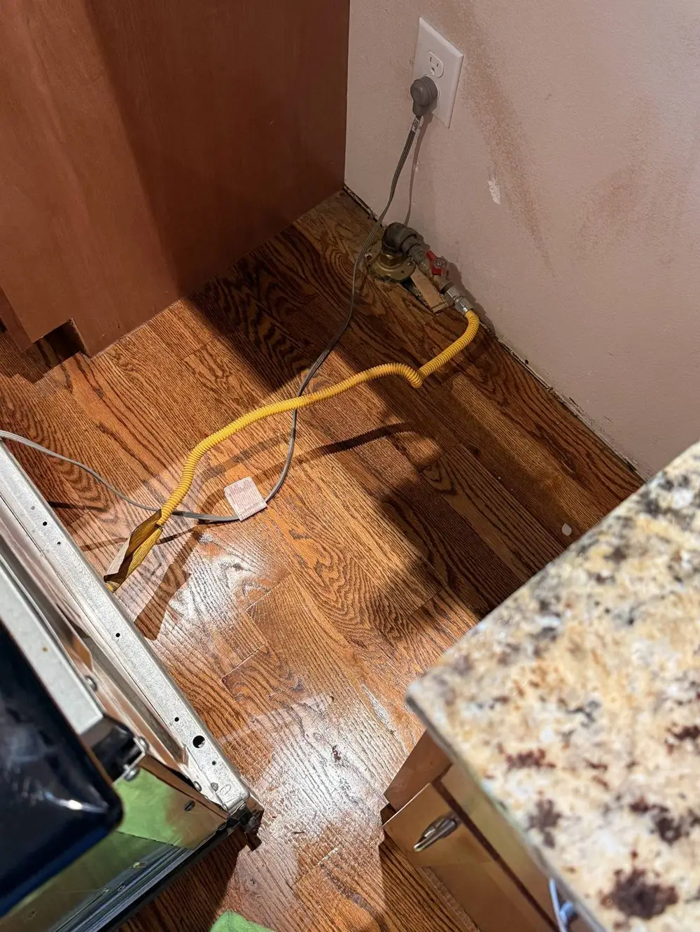 Behind a pulled-out kitchen appliance during an L&G Cleaning deep clean