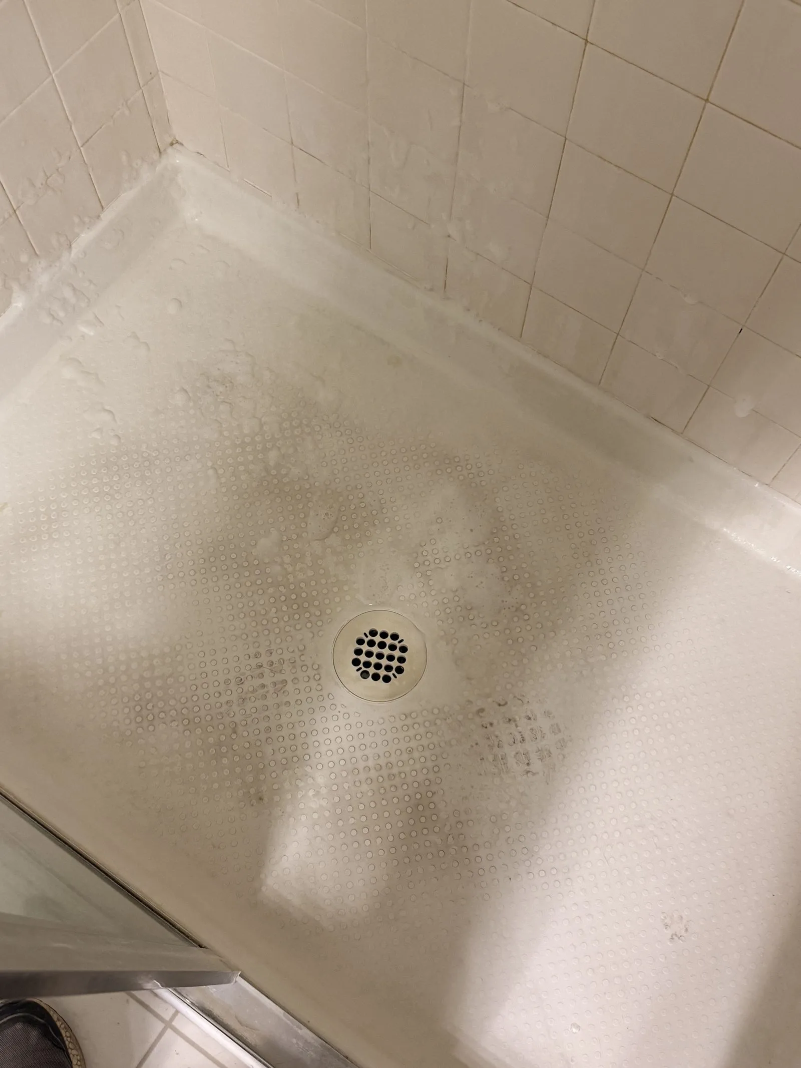 Second shower pan with heavy soap scum and grime before cleaning